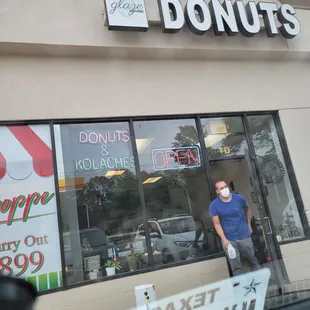 a man standing in front of a donut shop