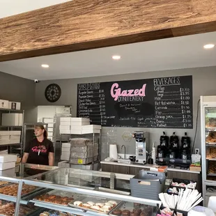 a woman behind the counter of a bakery