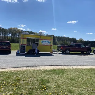 a yellow food truck parked in a parking lot