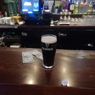a pint of guinness on a bar