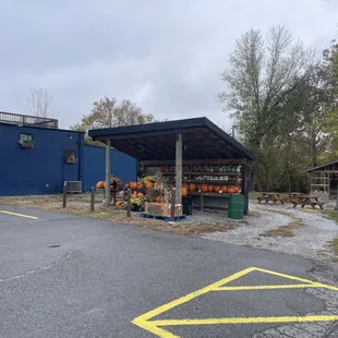 Picnic Tables on the side for outdoor eating. Plus what looks like a fruit stand they&apos;re selling pumpkins at.