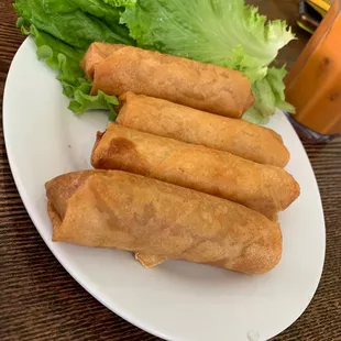a plate of fried spring rolls and lettuce