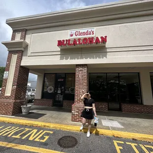 a woman standing in front of a restaurant
