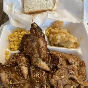 Turkey wing and smothered pork chop over rice with corn and smothered potatoes