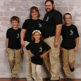 a family posing in front of a brick wall