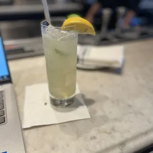 a glass of lemonade next to a laptop