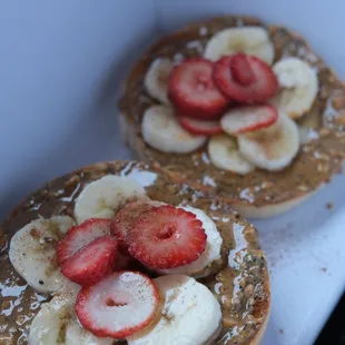 Nut and seed butter bagel with banana, strawberry, and agave syrup.