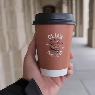 a hand holding a coffee cup