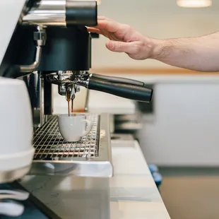 a person using a coffee machine