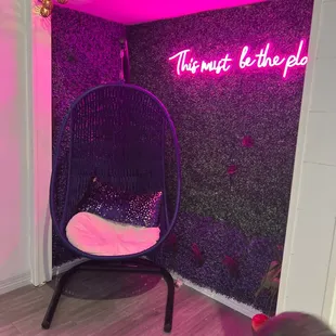 a chair in front of a neon sign