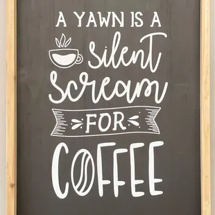 a sign that says a yawn is a silent scream for coffee
