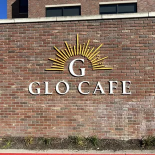 the glo cafe logo on a brick wall