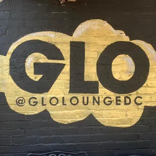 the glo lounge lounge logo painted on a brick wall
