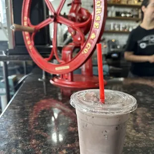 a cup of iced coffee with a straw
