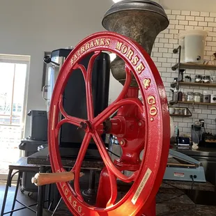 a red coffee grinder in a coffee shop