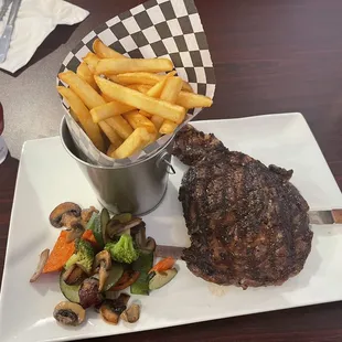 Fire grilled Ribeye steak with grilled veggies, fries and a Mexican glass coke.