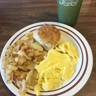 a breakfast plate with biscuits, eggs, hash browns, and a biscuit