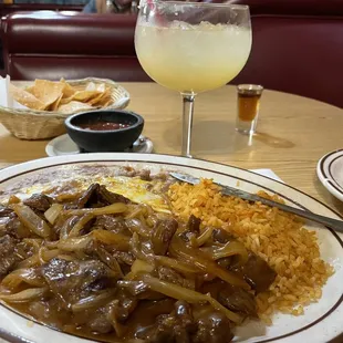 Delicious dinner of chips and salsa, steak ranchero, beans, rice, side salad, and a margarita to top it off.