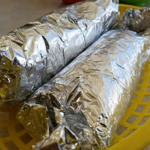 two burritos wrapped in foil