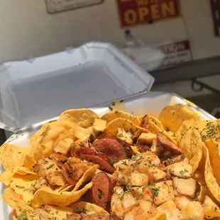 Ultimate Nachos topped with cheese, shrimp, chicken, beef, sausage, and boudain rice. My heart &amp; tummy are happy.