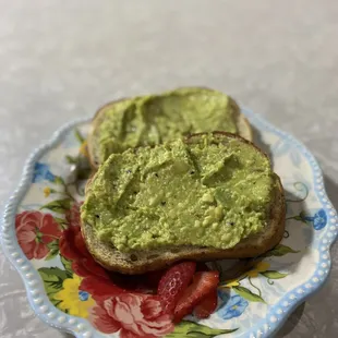 two slices of toast with guacamole on a plate