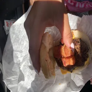 a hand holding a hamburger