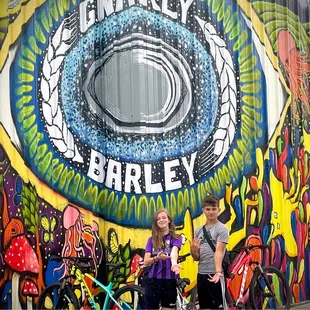 a man and a woman standing in front of a mural