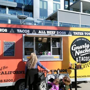 a group of people standing in front of a food truck