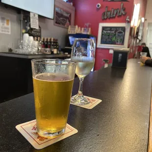 two glasses of beer on a bar