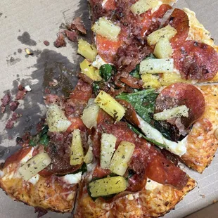 Thin crust, pizza with pepperoni, pineapple, bacon, spinach, and feta cheese