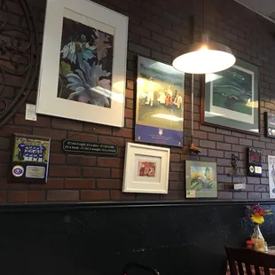 a brick wall with framed art