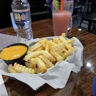 Fries with nacho cheese and one of their cocktails