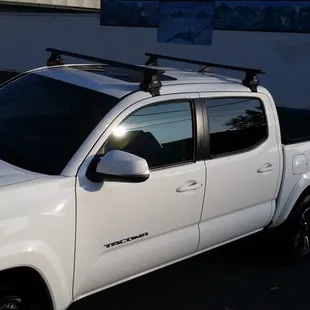 2016 Tacoma, unofficial Thule rack system with black AeroBlade bars.