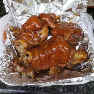 a plate of chicken wings covered in bbq sauce