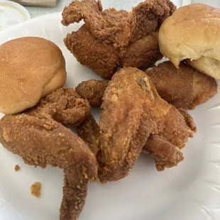 a plate of fried chicken and rolls
