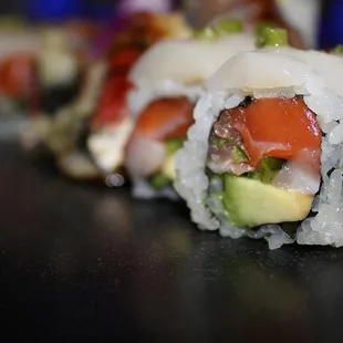 The Amazing Roll is made with yellowtail, tuna, salmon, jalapeno &amp; avocado then topped with fresh scallop &amp; wasabi sasa.