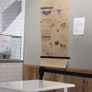Discreet side menu is drawn on the paper roll hung on the wall.