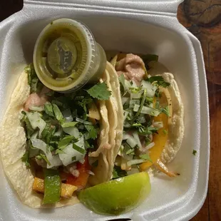 two tacos in a styrofoam container