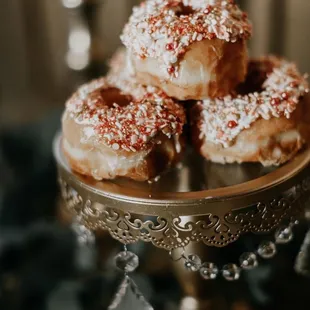 a metal cake stand with a bunch of donuts on it