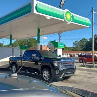 a black pickup truck at a gas station