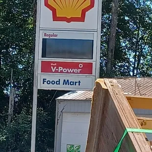 a shell gas station sign in the foreground