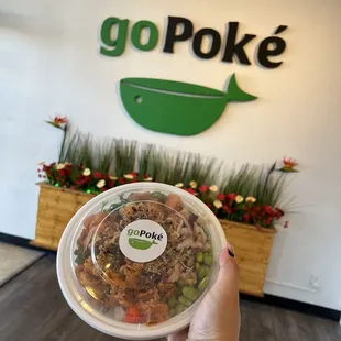 a hand holding a bowl of food