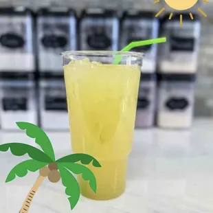 a glass of lemonade with a straw and a palm tree