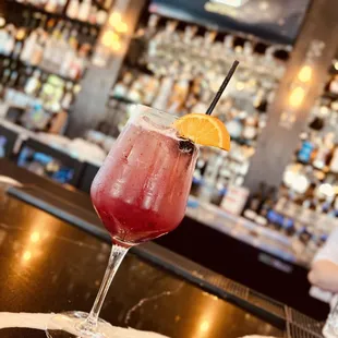 a glass of wine with a slice of orange