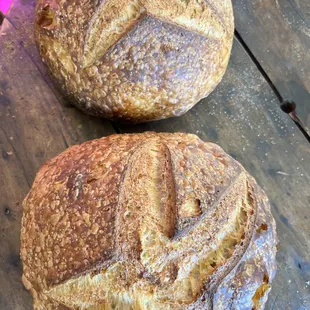 two loafs of bread on a wooden board
