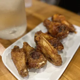 a plate of chicken wings and a glass of water