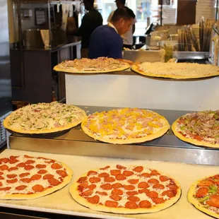 a variety of pizzas on display