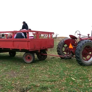 a tractor pulling a wagon with people in it