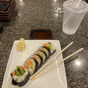 a plate of sushi and chopsticks