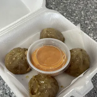 a container of food with sauce in it